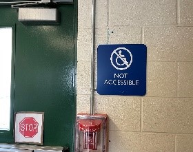 A not accessible sign hanging by an inaccessible exit