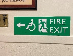 An accessible fire exit sign pointing to the direction of an accessible exit